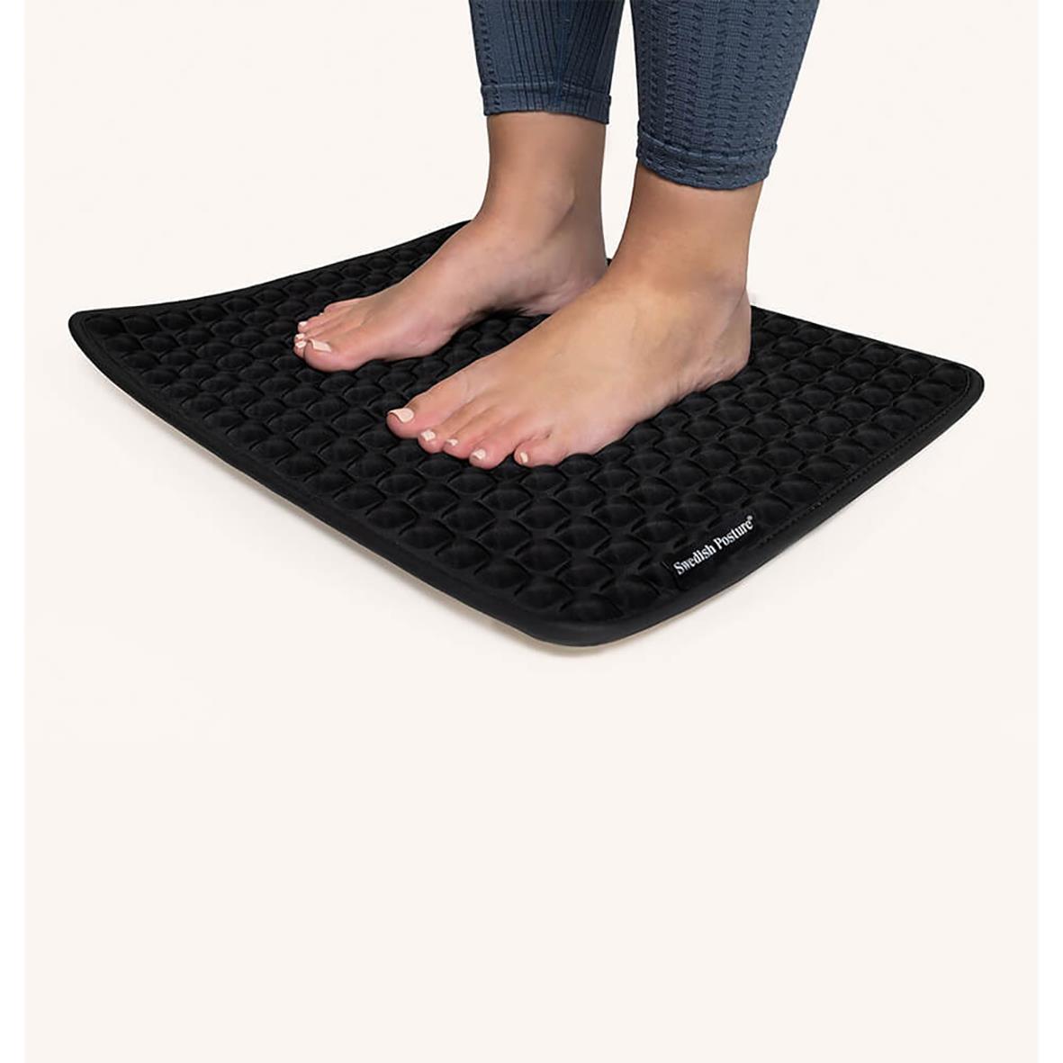 Person står på en svart ståmatta Swedish Posture Kylande för att förbättra hållningen