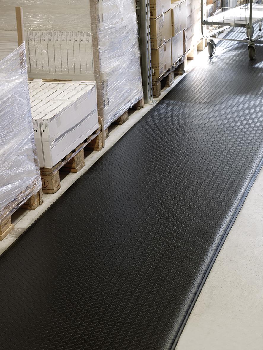 Svart arbetsplatsmatta 91x100cm i industrimiljö med pall och hyllor