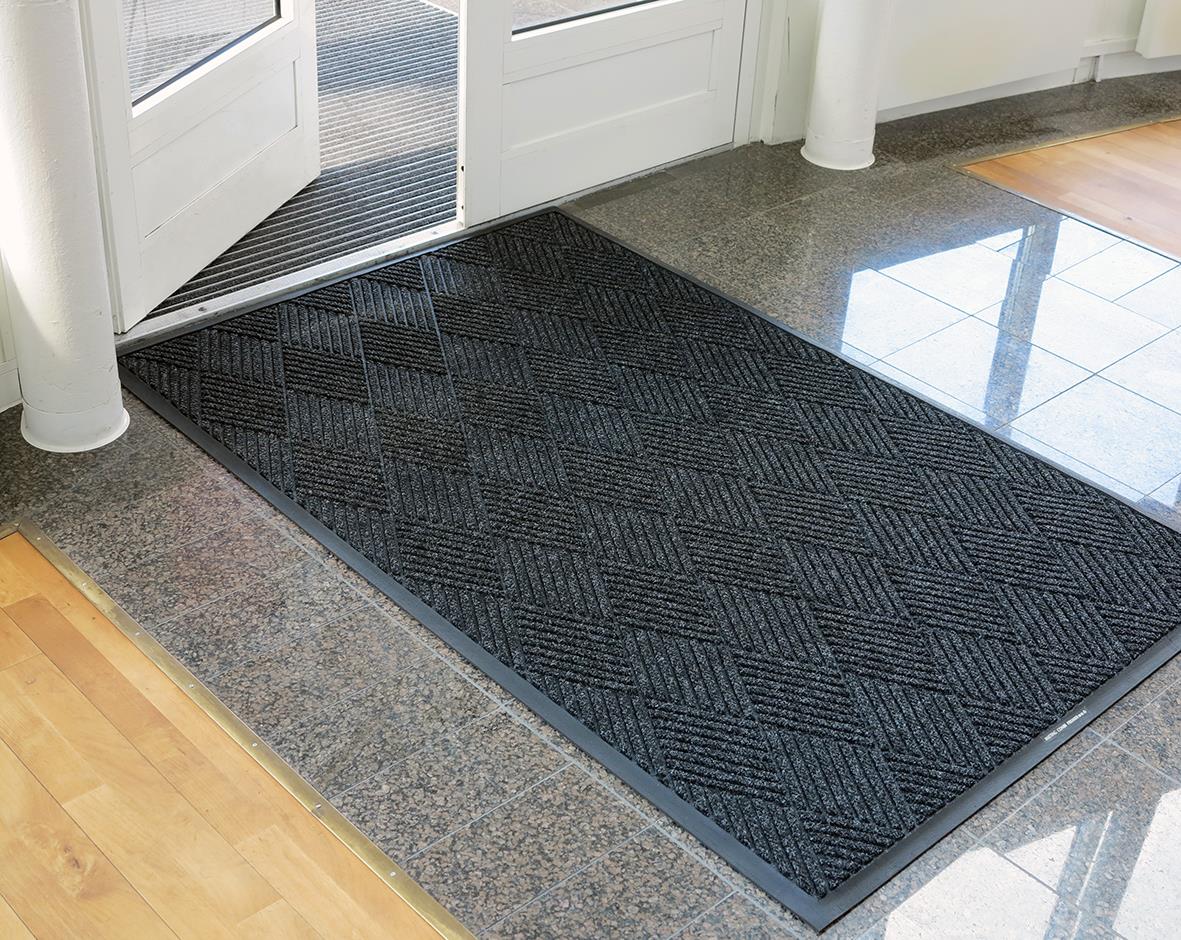 Svart kombinationsmatta Matting Combi Premier 114x175cm framför ytterdörren på en entré