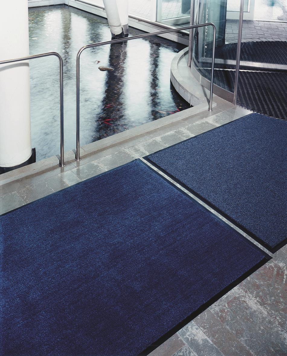 Grå torkmatta matting Solett 80x60cm placerad vid ingången till en byggnad