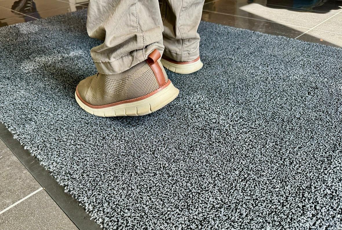 Person står på grå entrématta Activa Micro Plus 60x90cm