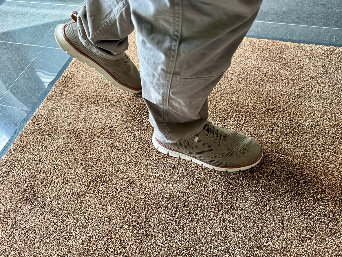 Person som går på en beige entrématta Activa Micro Plus 90x150cm
