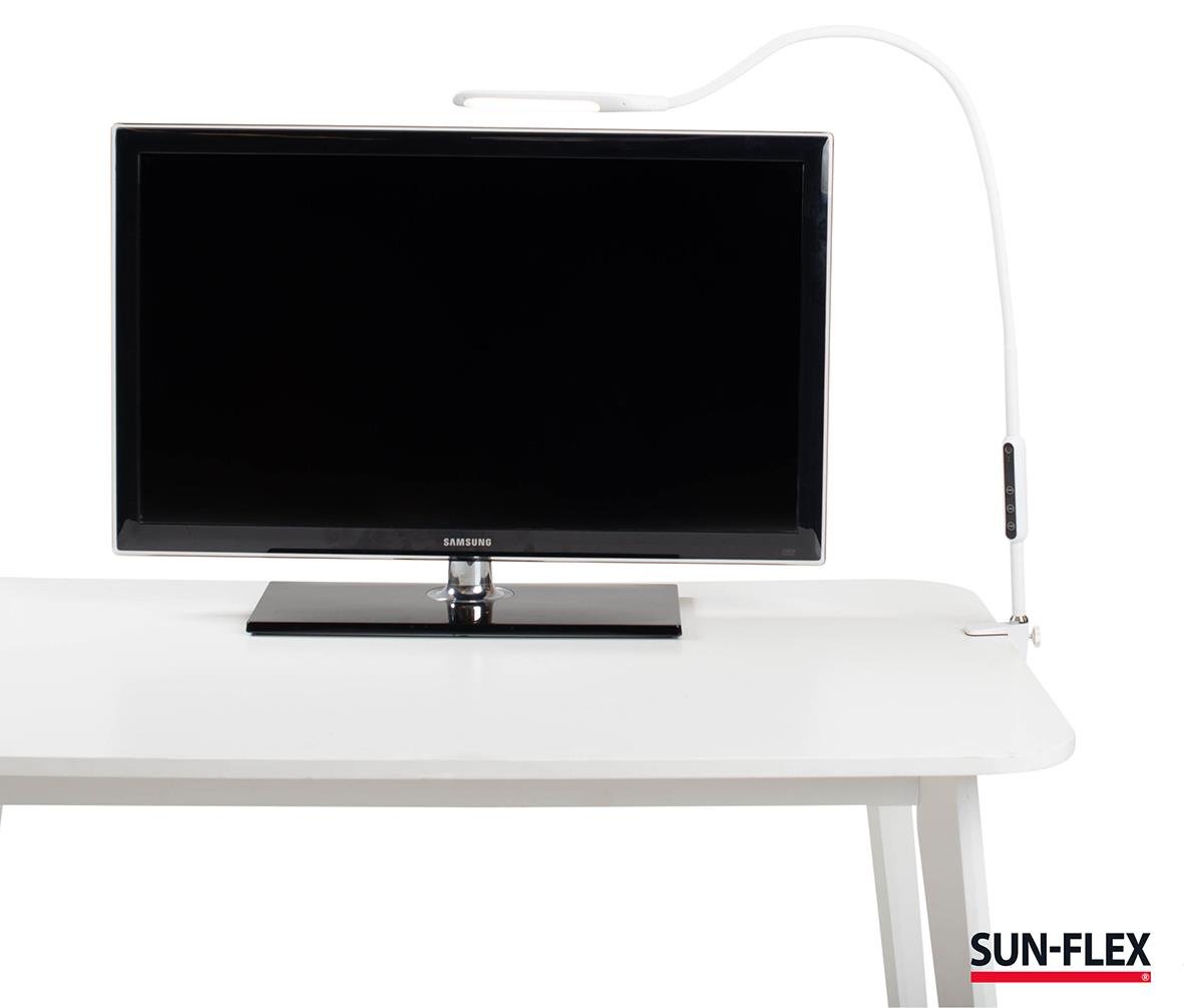 Bordslampa Sun-Flex Desklite Vit placerad på ett vitt skrivbord med en TV och en växt