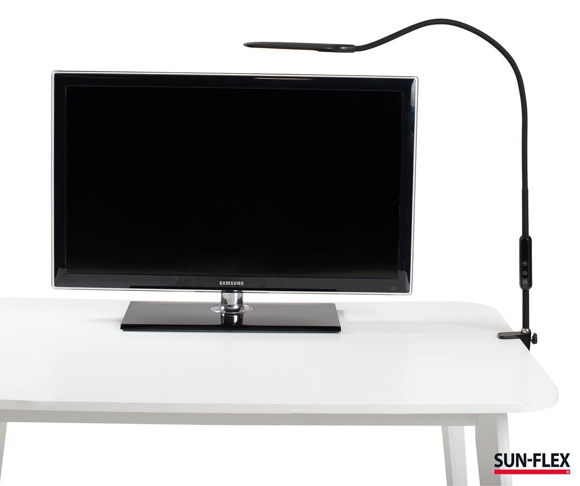 Bordslampa Sun-Flex Desklite svart placerad på ett skrivbord framför en datorskärm