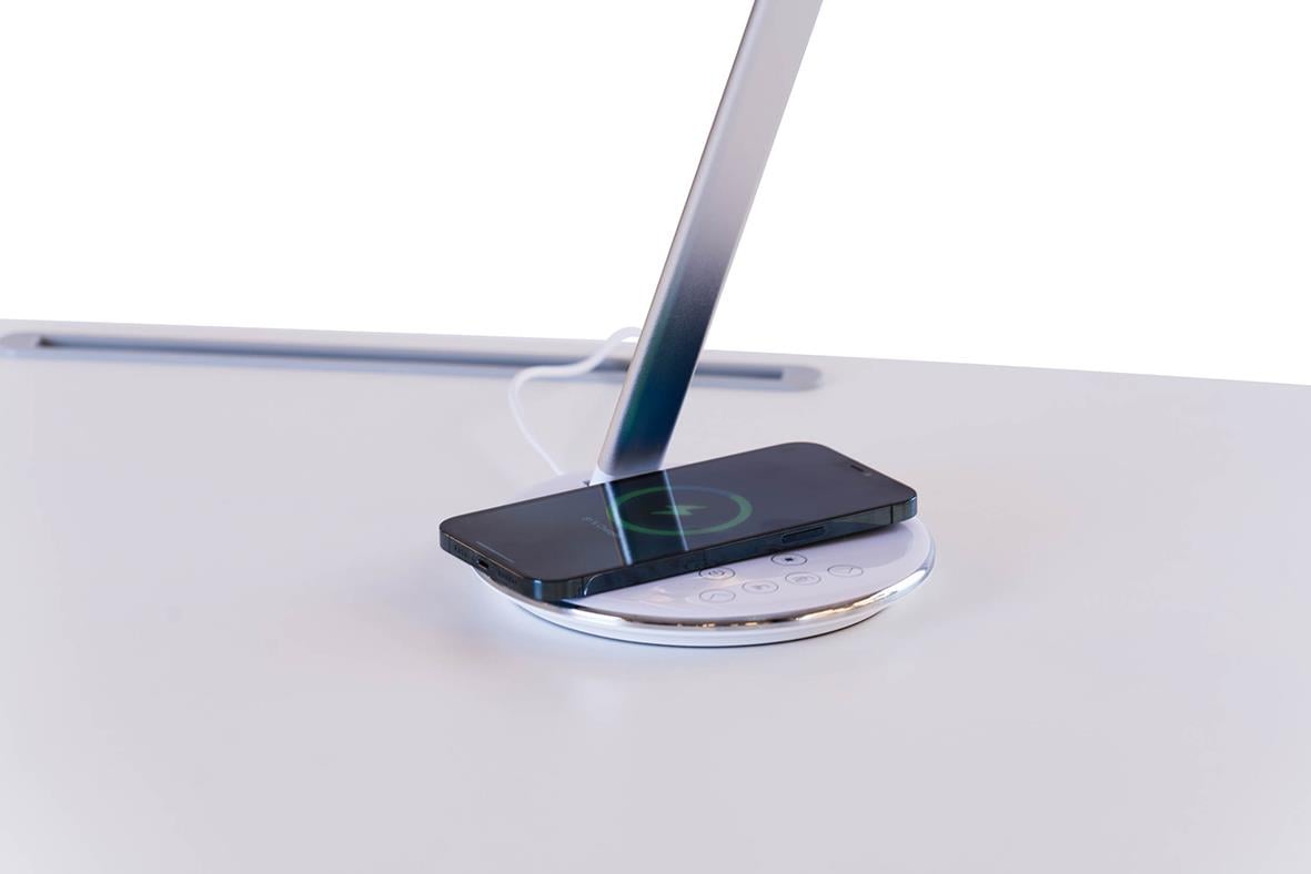 Bordslampa Sun-Flex Qlite Vit som laddar en smartphone på ett bord