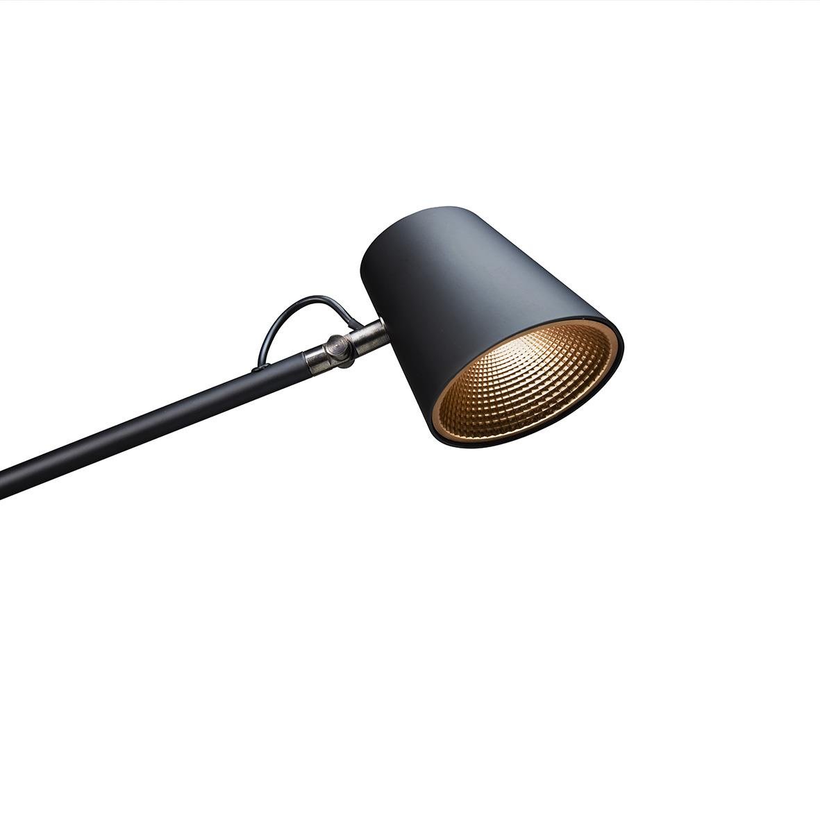 En svart vägglampa med riktad ljuskälla