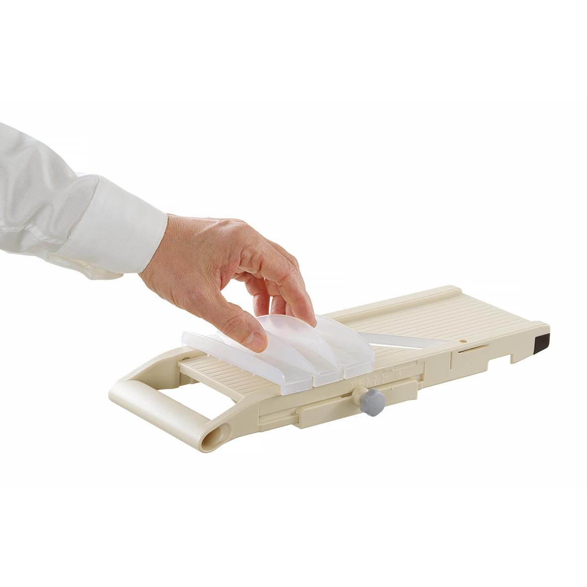 Person som använder en skärbräda för att skära eller hantera mat, med en vit bakgrund