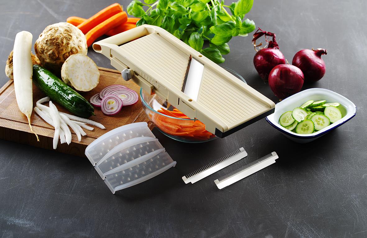 Skärbräda med grönsaker som morötter, rödbetor, gurka, lök och sallad på svart bakgrund