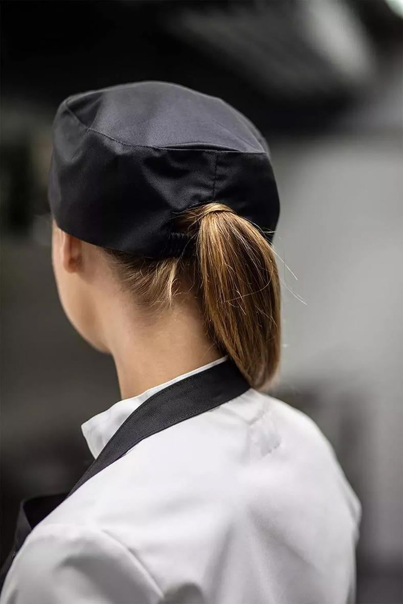 Kockmössa Segers svart låg L/XL på person i vit kockrock, bakifrån