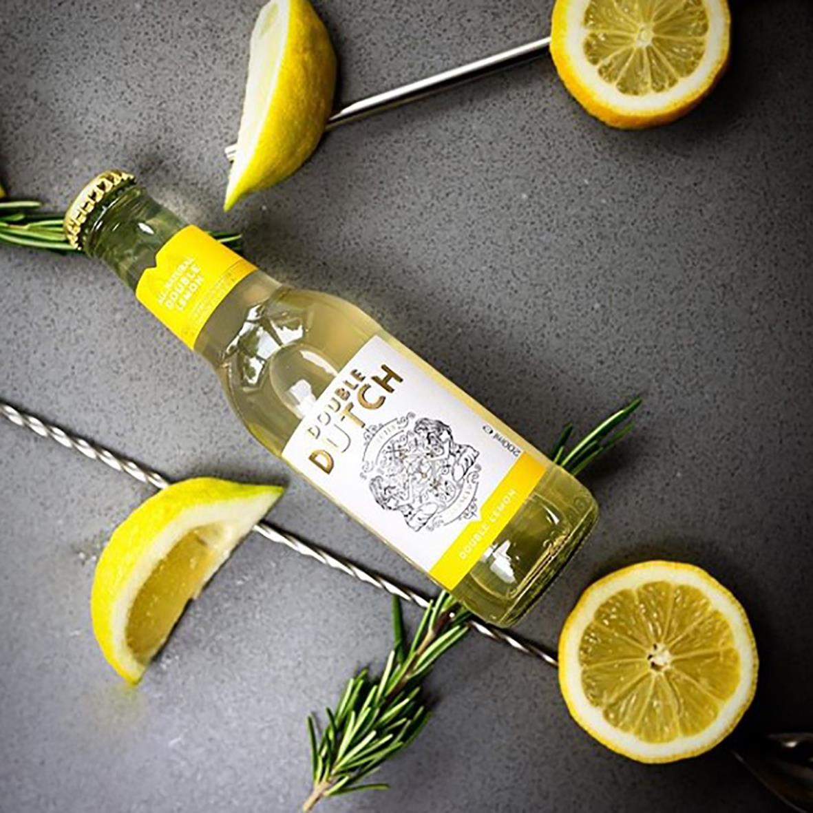 Double Dutch Tonic Double Lemon 20cl med citron- och rosmarinstänk, omgiven av citronskivor och rosmarin