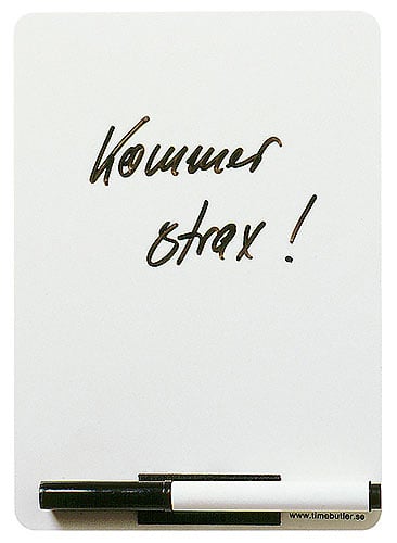 Vitwhiteboard med penna och sudd, texten Kommer snart! skriven på den