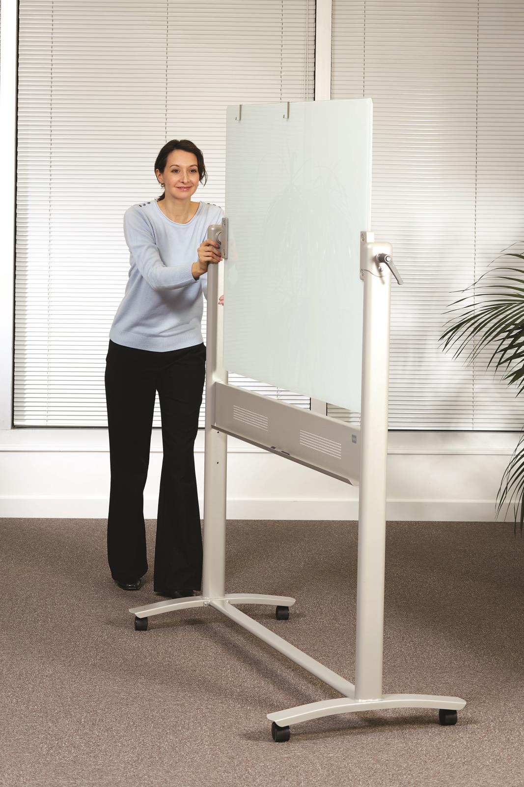 Kvinna skriver på en magnetisk glastavla Nobo Pivot i ett kontorsrum