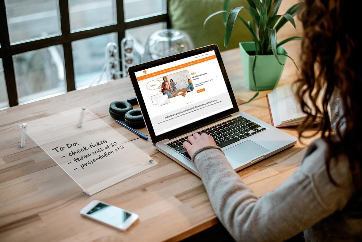 Person använder en transparent whiteboardtavla Nobo Mini Vinklad A4 vid ett skrivbord med laptop och anteckningar