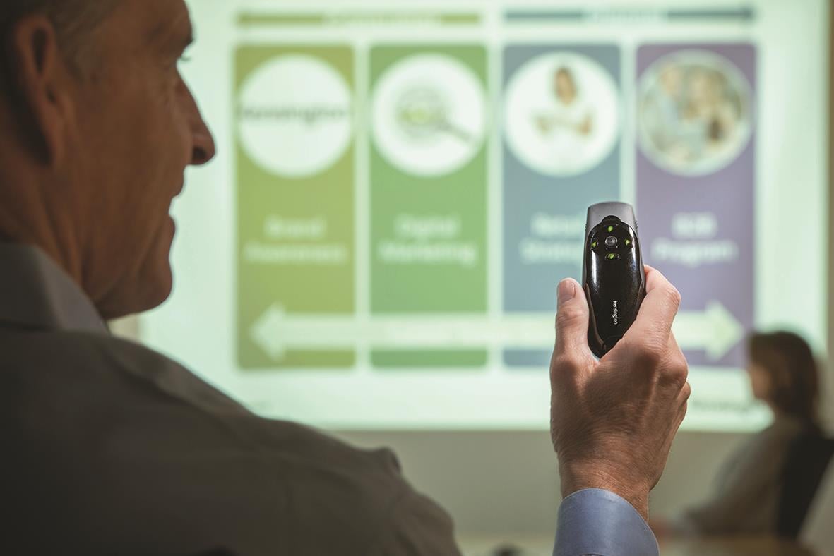 Presentatör med grön laserpekare som visar en presentation på en skärm