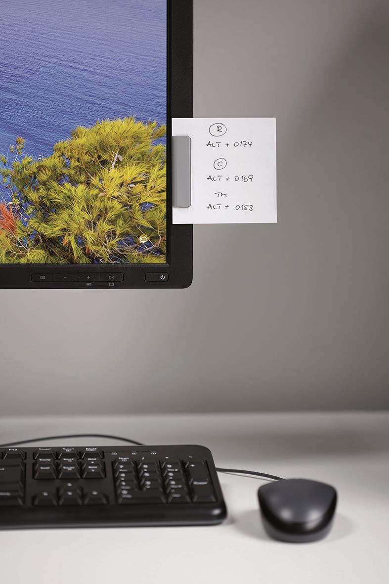 Datorhörn med monitor, tangentbord, mus och whiteboard med anteckningar