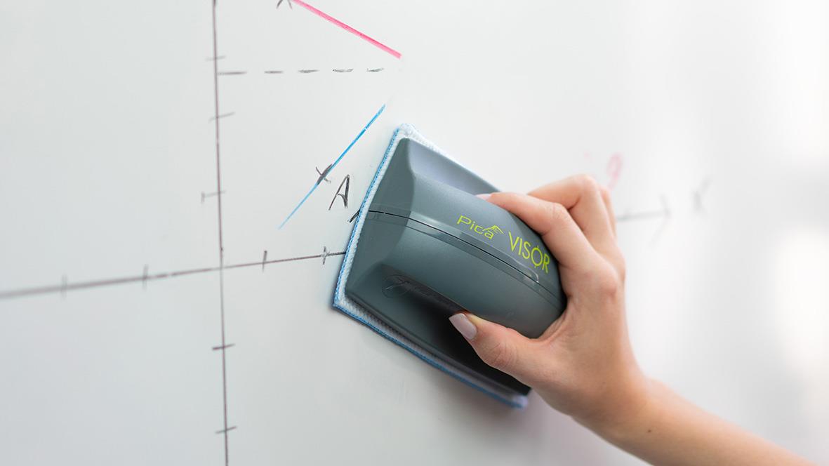 Hand som använder en whiteboard-visor för att skriva på en whiteboard