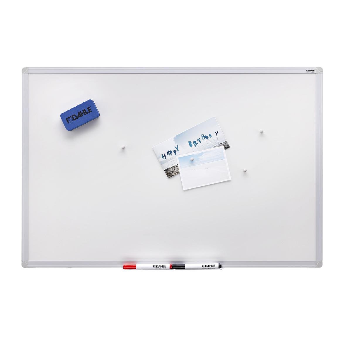 Vit whiteboard med magnet, papper och pennor, samt en blå magnet med text