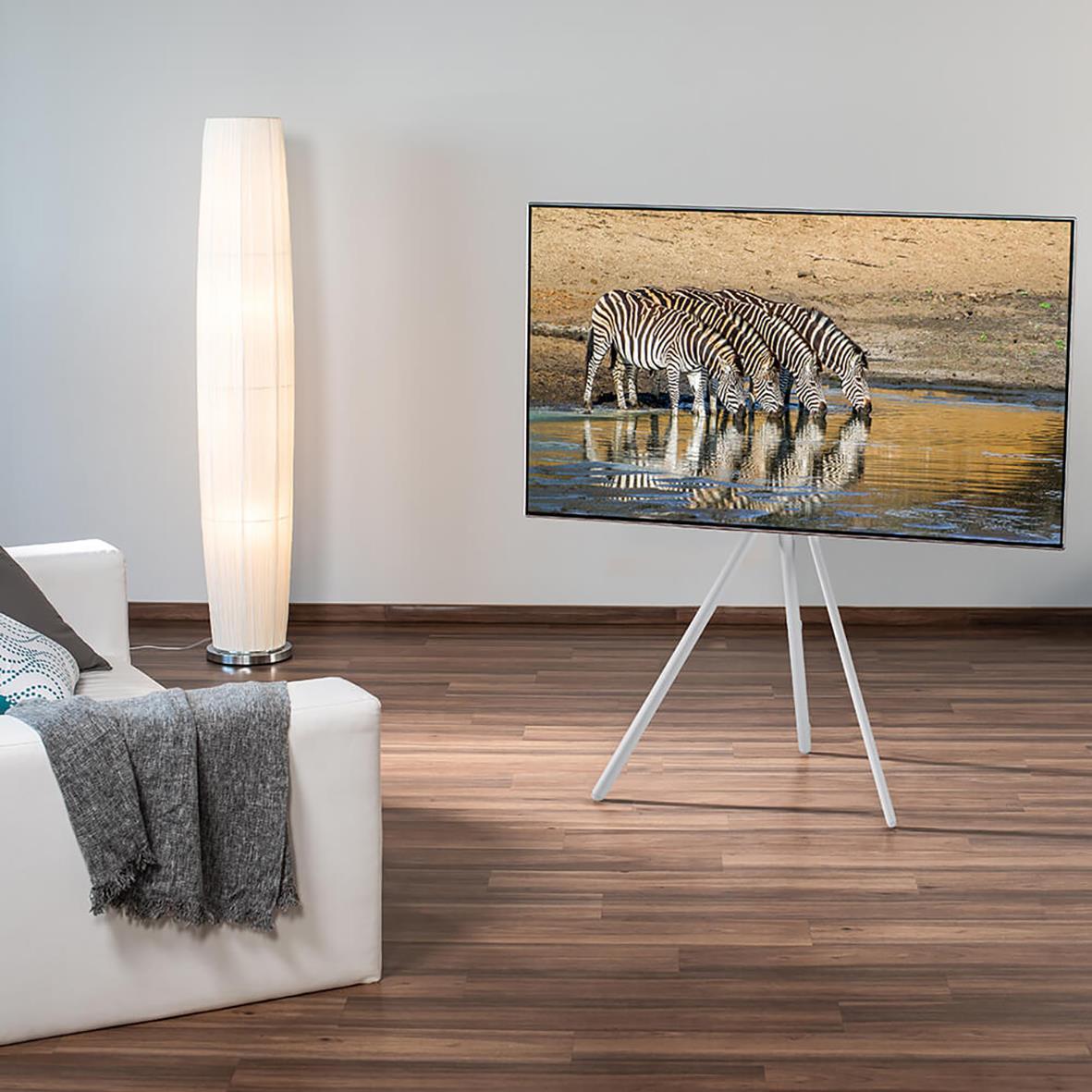 Vit TV-stativ för golv upp till 75 tum med TV och soffa i vardagsrum