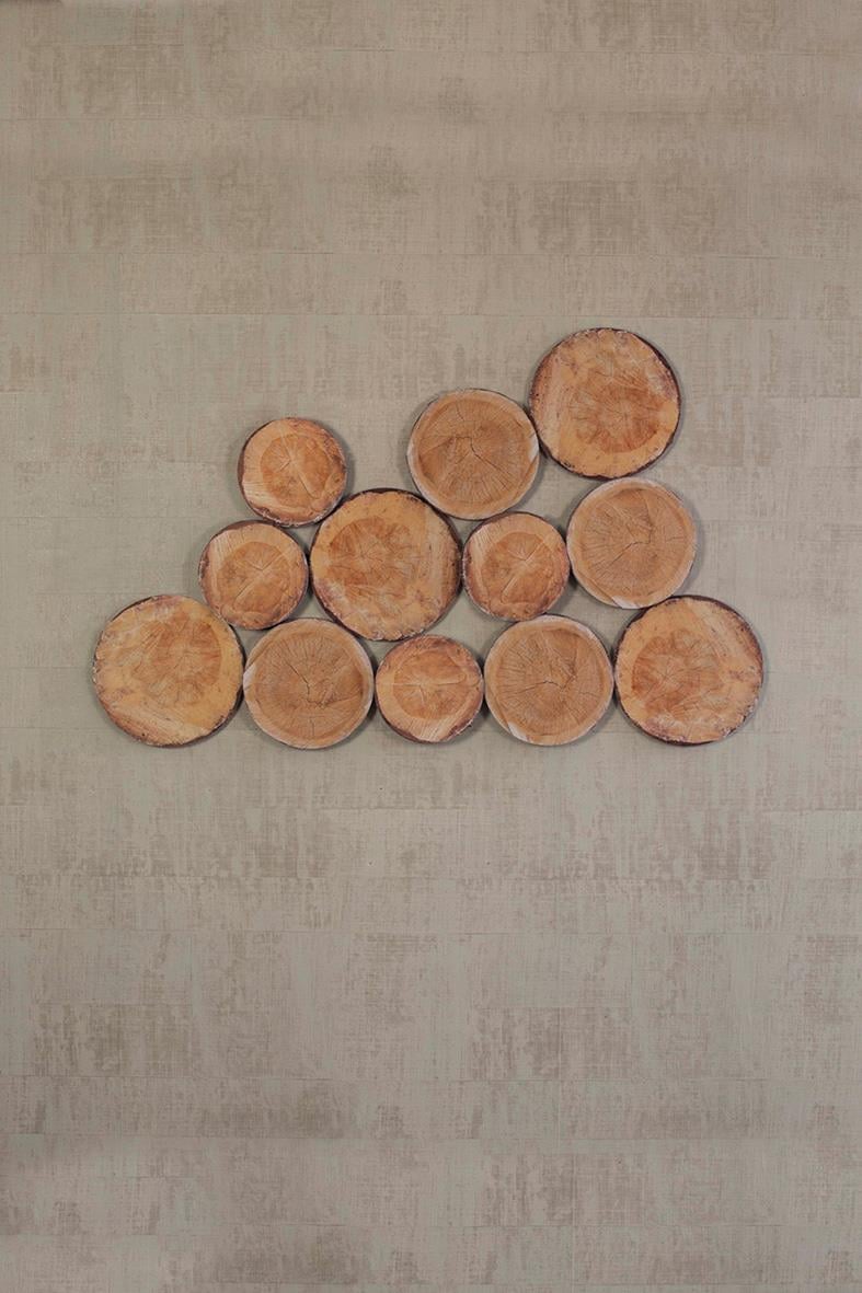 Grå ljudabsorberande Woodstock EcoSund i form av träbitar på en ljus bakgrund