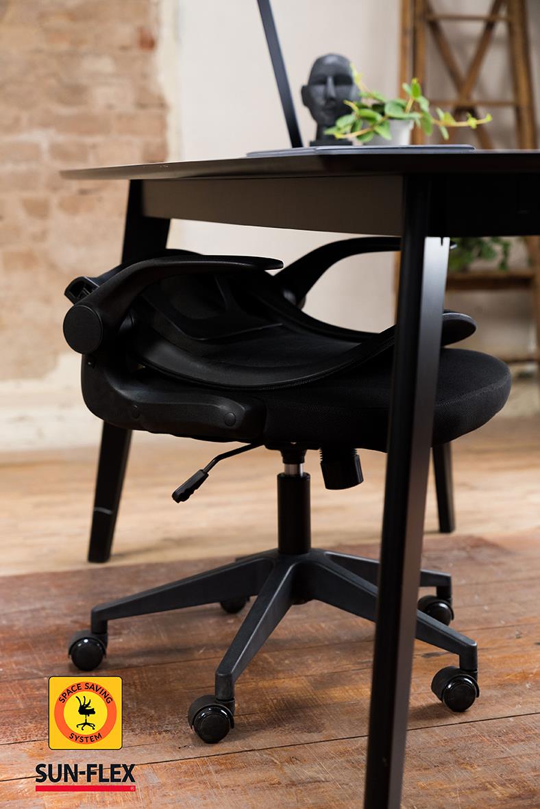 Svart kontorsstol under ett skrivbord med växter och konstnärlig inredning i bakgrunden