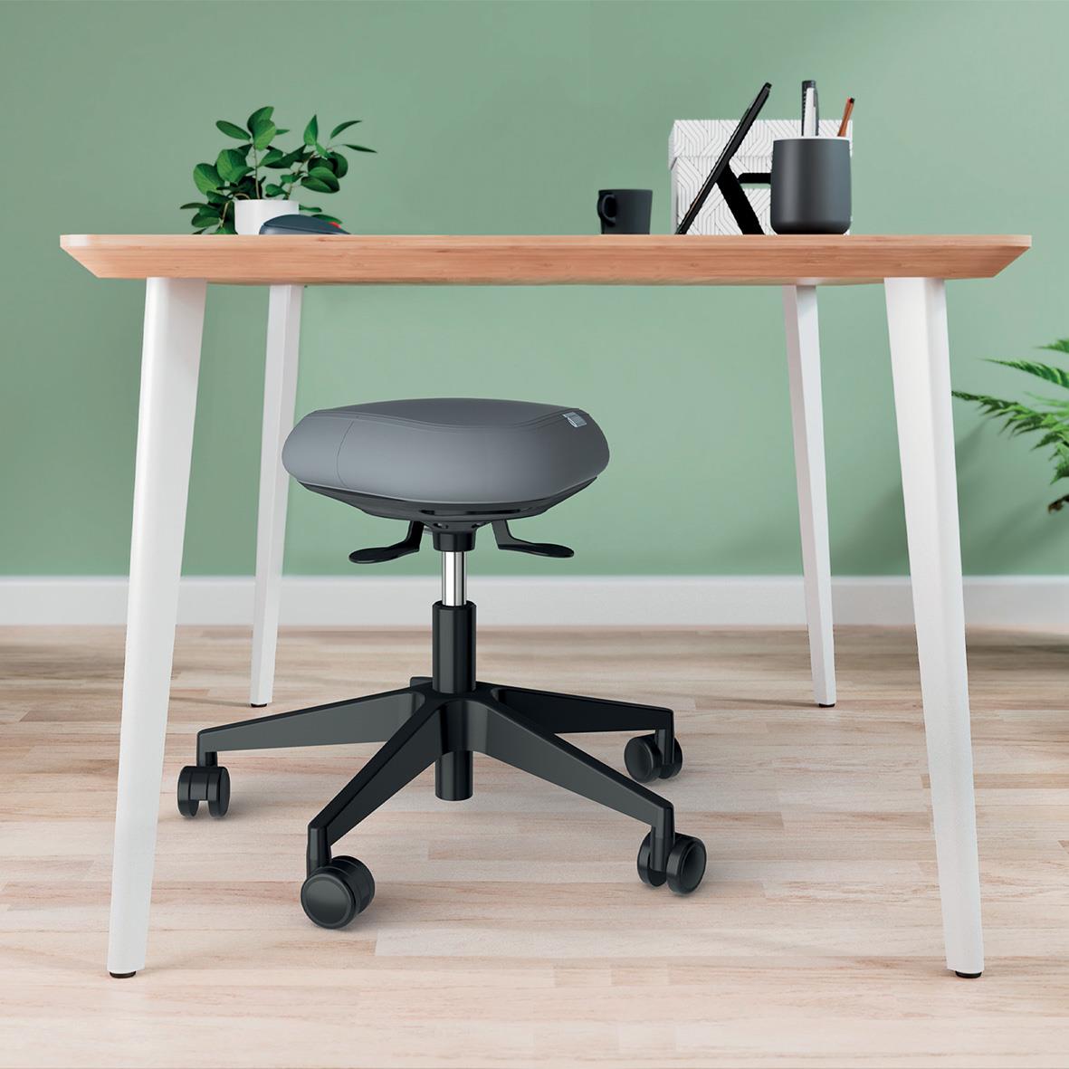 Sittpall Leitz Ergo Active med hjul framför ett skrivbord med gröna växter och skrivmaterial