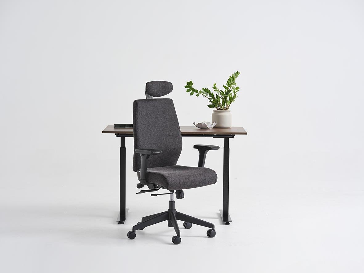 Kontorsstol Lotus Adenau med justerbart svankstöd och huvudstöd i svart framför ett skrivbord