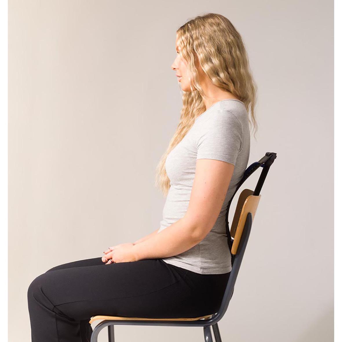 Kvinna sitter rakt upp med rak rygg i en stol, utför en ryggsträckarövning