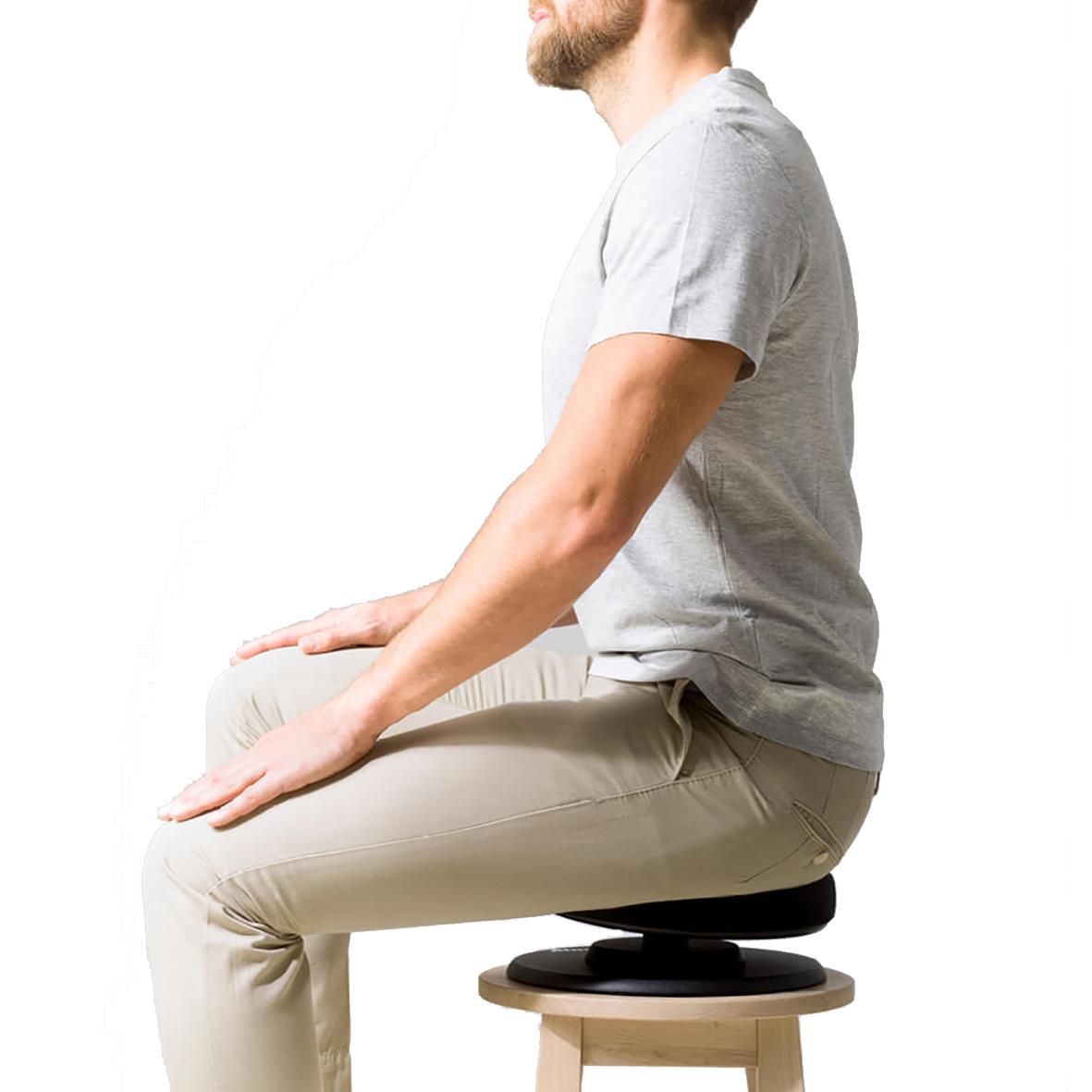 Person som sitter på en stol med rak rygg och bra hållning, visar korrekt svensk hållning