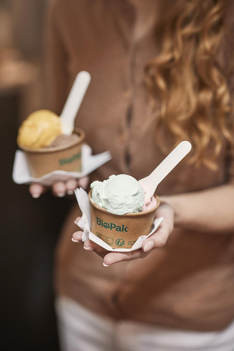 Två personer håller i glasskopor med pappersbestick Duni Pluma, vita, 9,5 cm, i pappersemballage