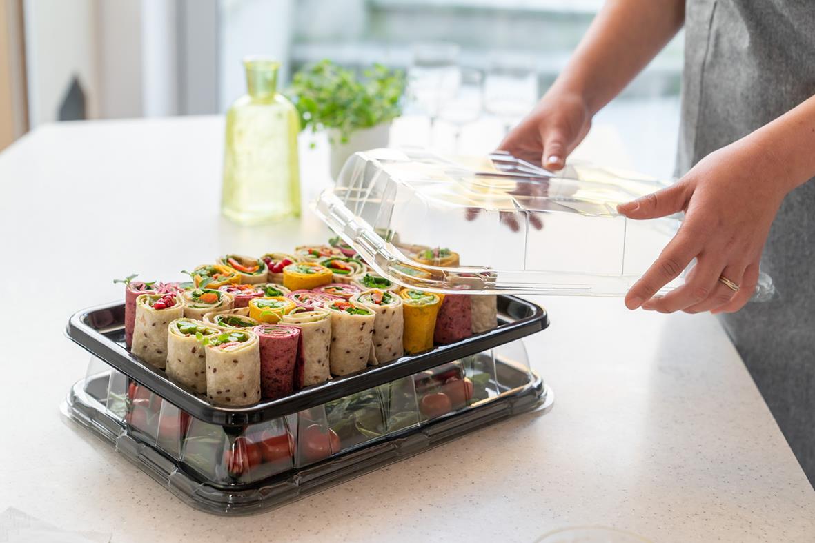 Person placerar ett uppläggningsfat med kupollock på ett svart fat, på köksbord
