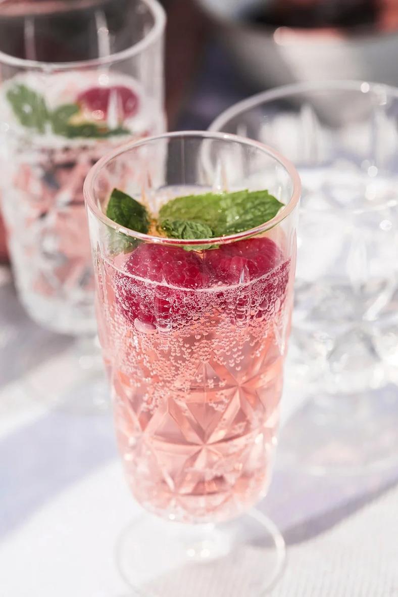 Fyrpack med rosa drinkar i höga glas med mint och bär