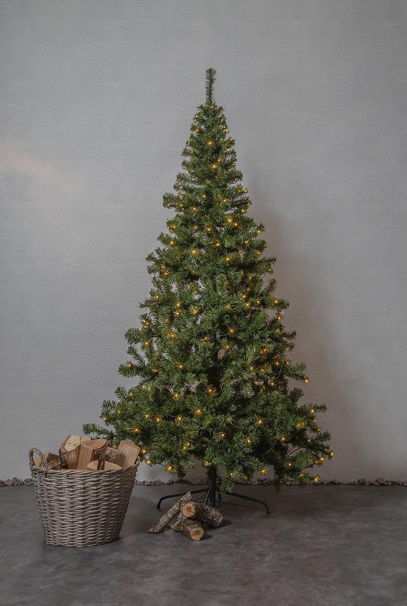 Julgran i Ottawa med 260 LED-lampor, 210 cm hög, står bredvid en korg med ved och några vedträn