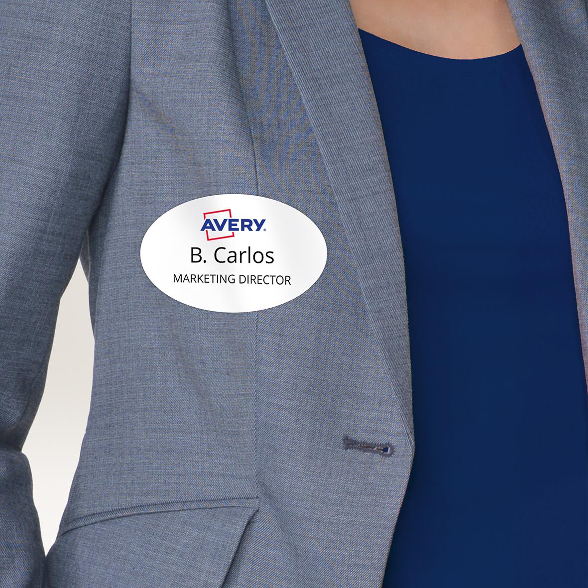 " av PVC-material med vit oval design, avtagbar, 85x50mm, bärs på en person i blå kostym."