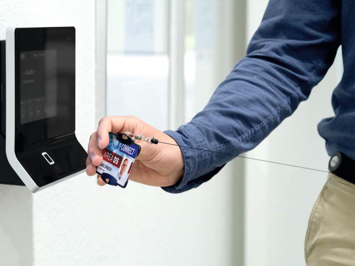 Person håller ett kreditkort framför en svart korthållare av ekologiskt material