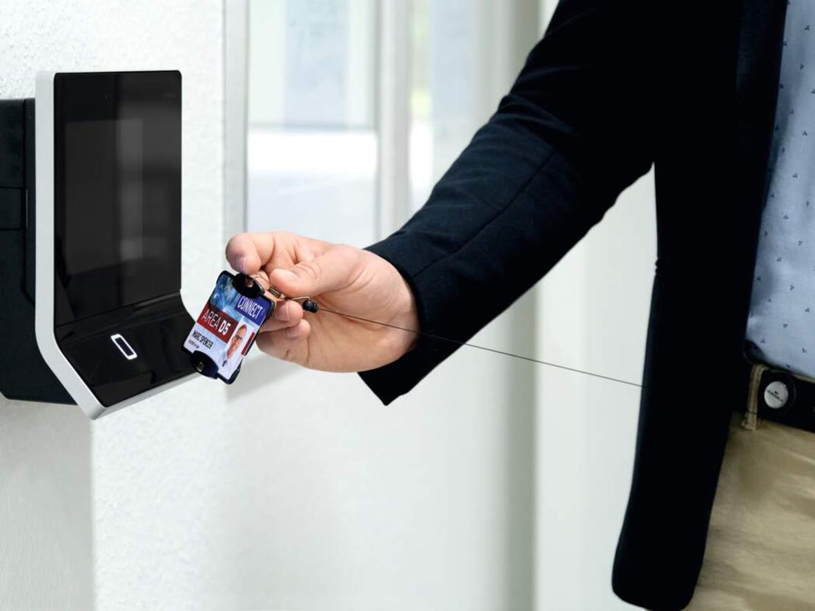 Person använder en svart korthållare för ett kreditkort vid en kortläsare