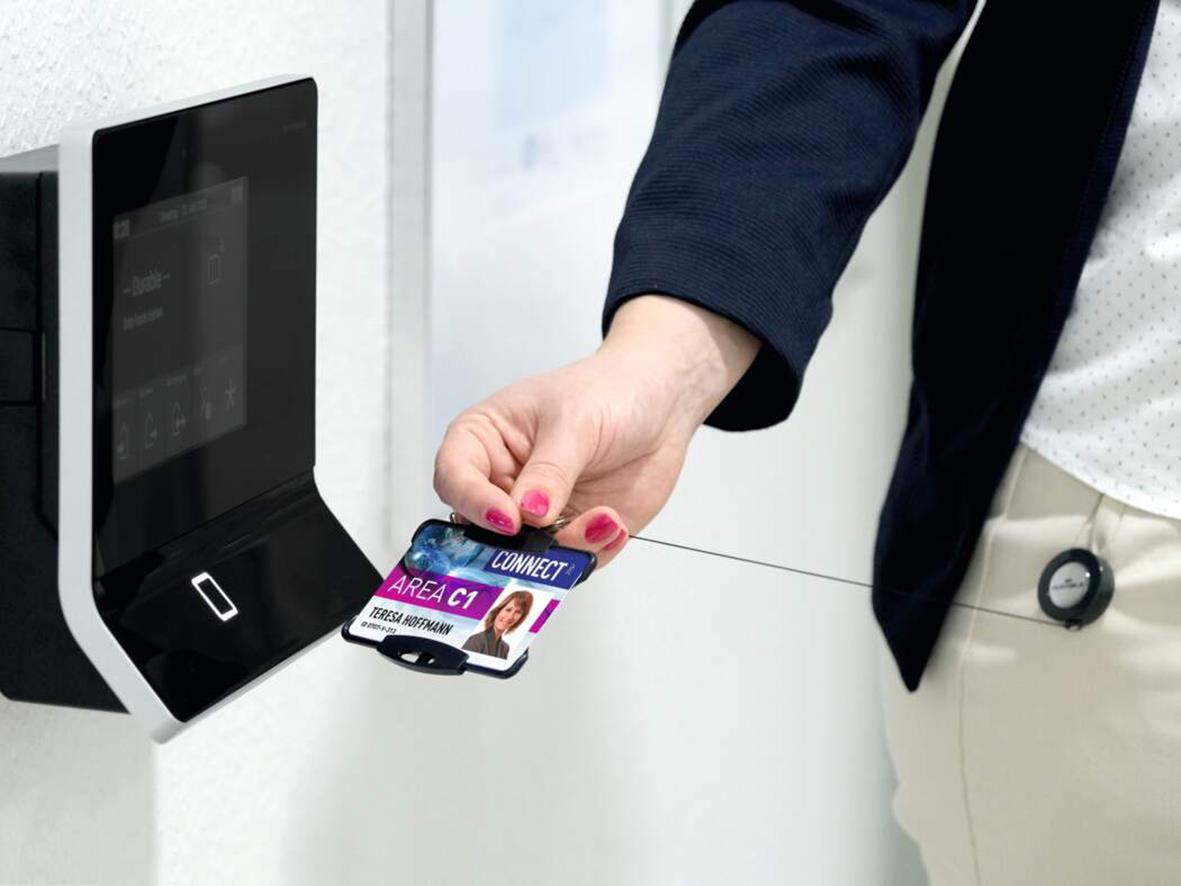 Person använder korthållare för ett ID-kort vid en kortläsare