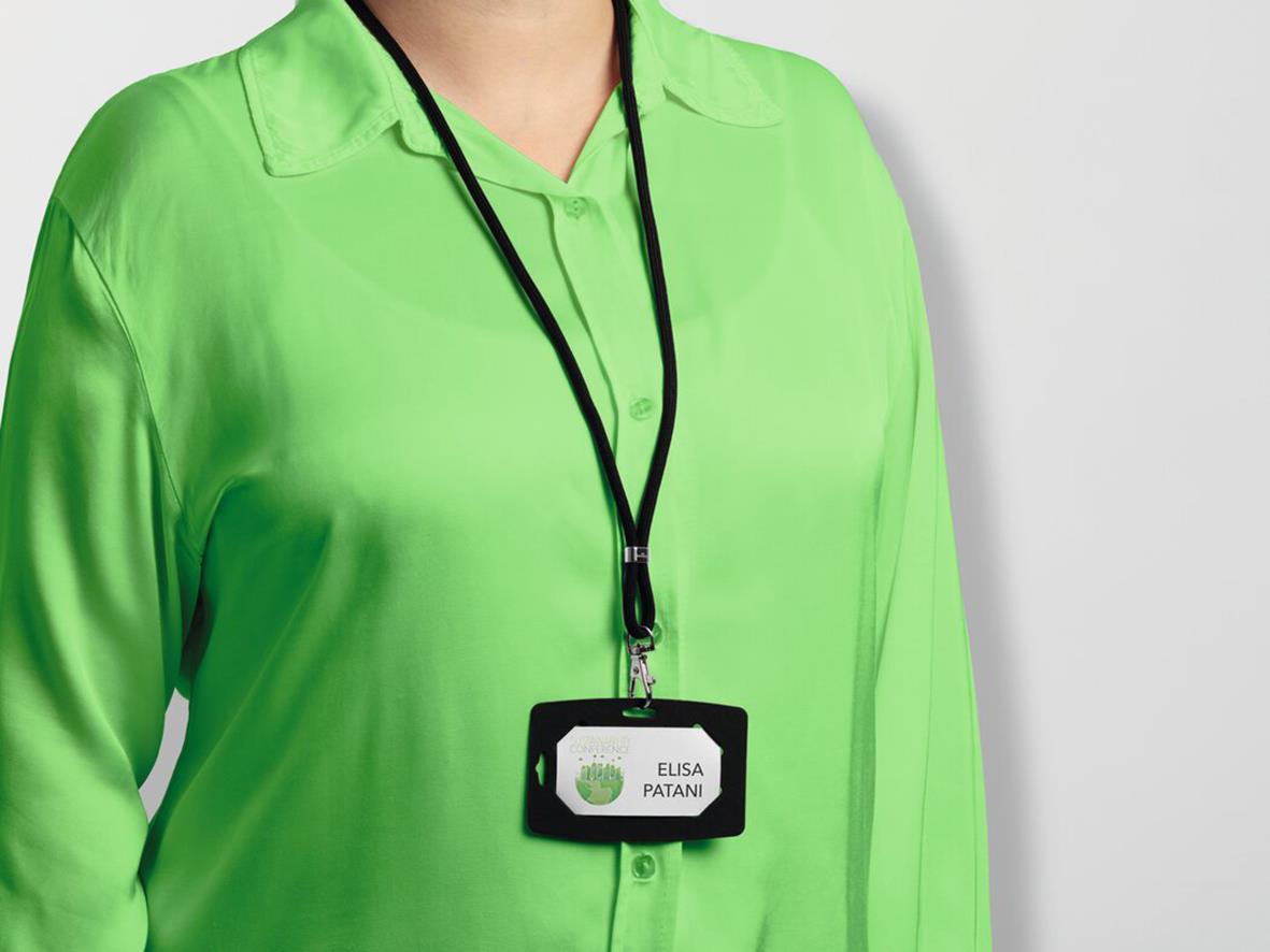 Person i grön skjorta med svart nyckelband och namnskylt