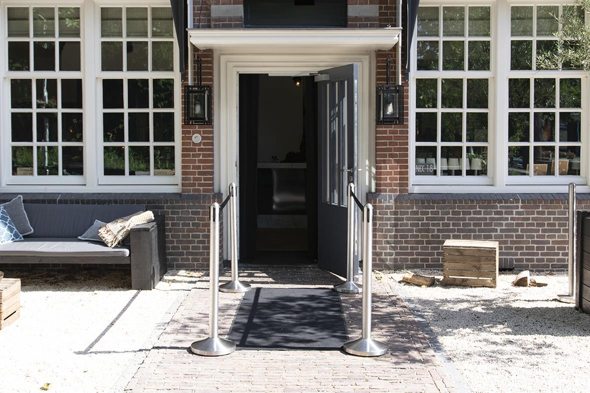 Avspärrningsrep Securit Ink Stolpe Indragbar Nylonrem Svart 210cm framför en byggnad