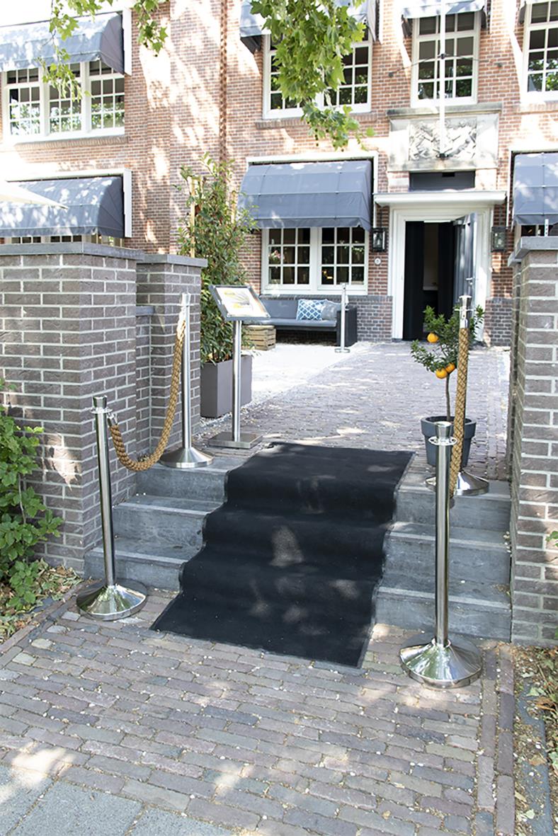 Avspärrningsstolpe Securit 4-väg Rostfri vid trappa med svart matta och guldkedjor