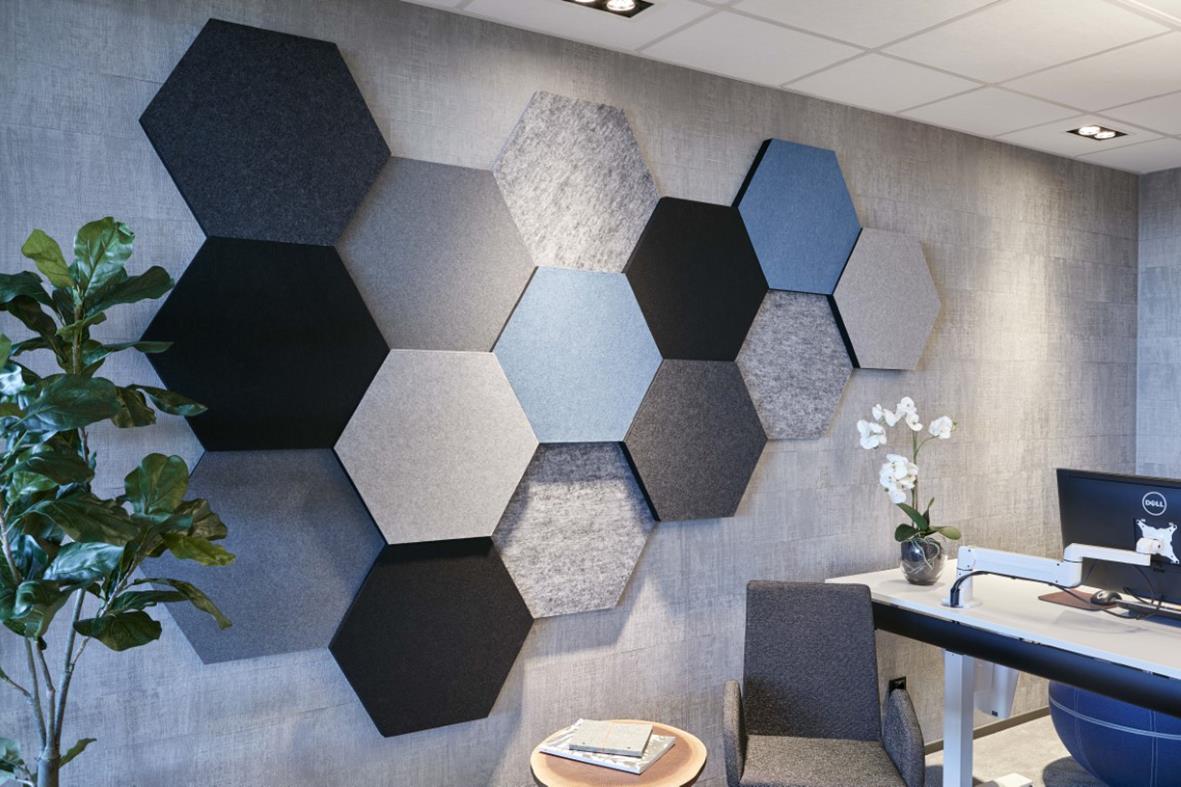Ljudabsorberande Honey 3-pack i blåa och gråa hexagonala former på kontorsvägg