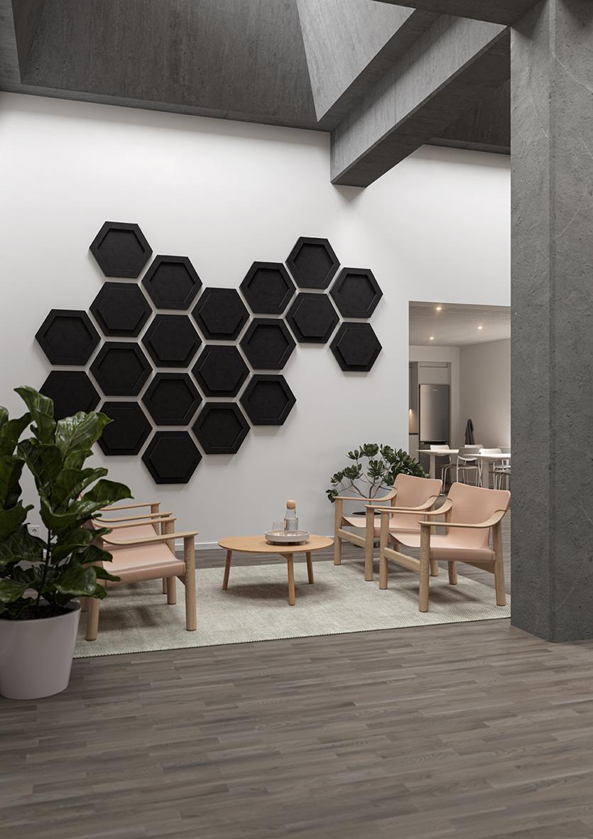 Ljudabsorberande hexagonala paneler i svart på vit vägg i modern inredning