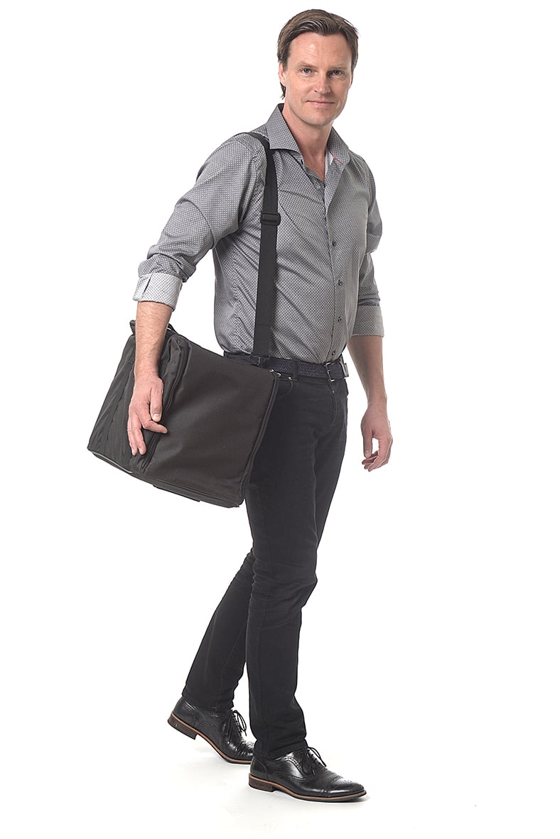 Man med svart broschyrställsväska i svart, bär den över axeln