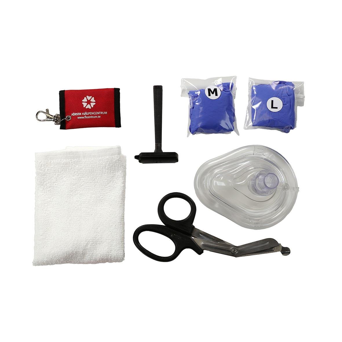 Säkerhetskit till hjärtstartare med förbandsmaterial, sax, mask, och instruktioner