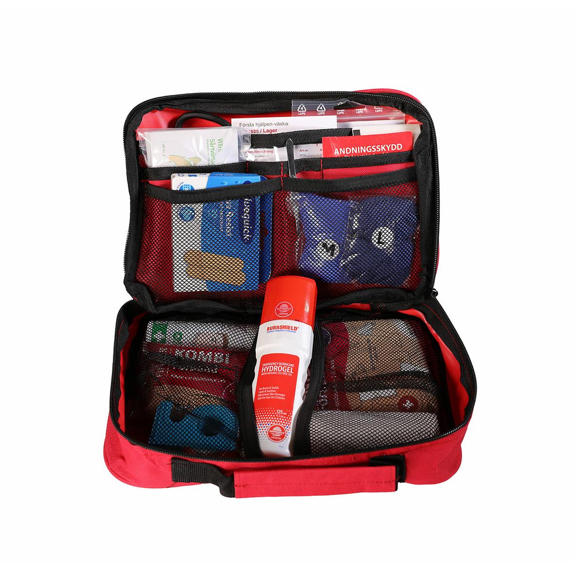 Första hjälpen väska med olika medicinska förnödenheter och skydd i ett öppet fall