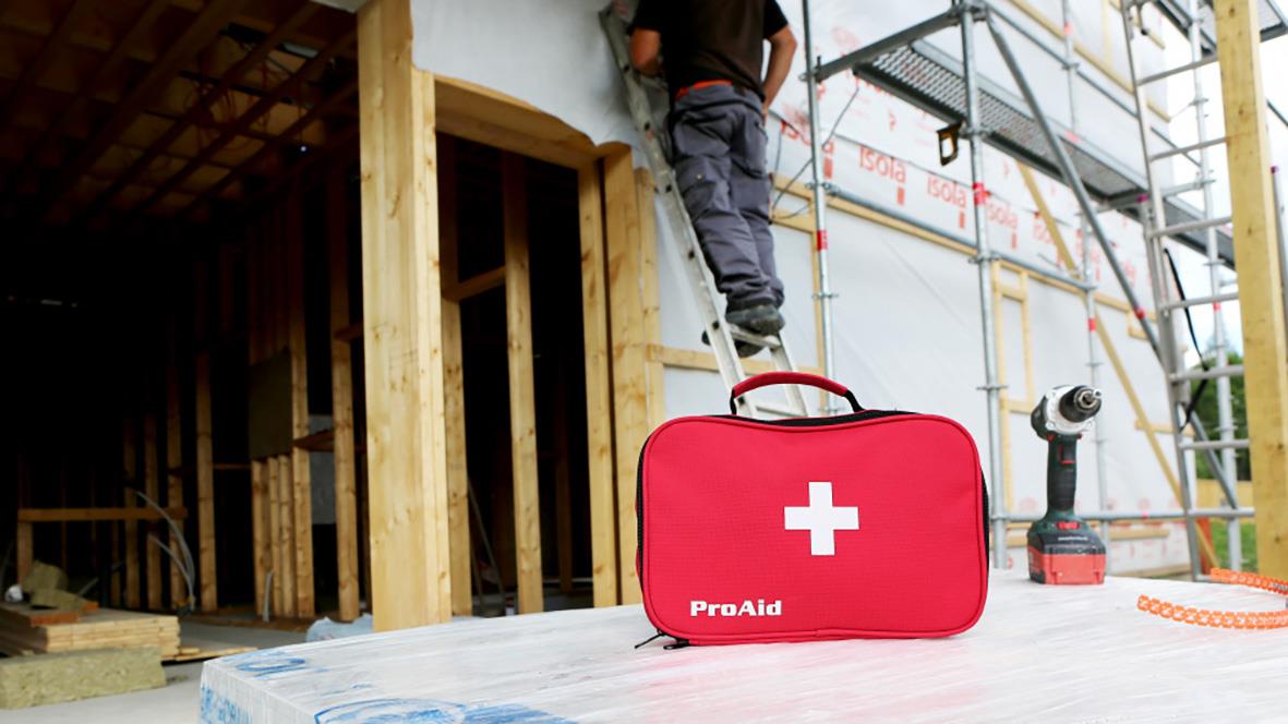 Första hjälpen ProAid väska på byggarbetsplats med byggnad och verktyg i bakgrunden