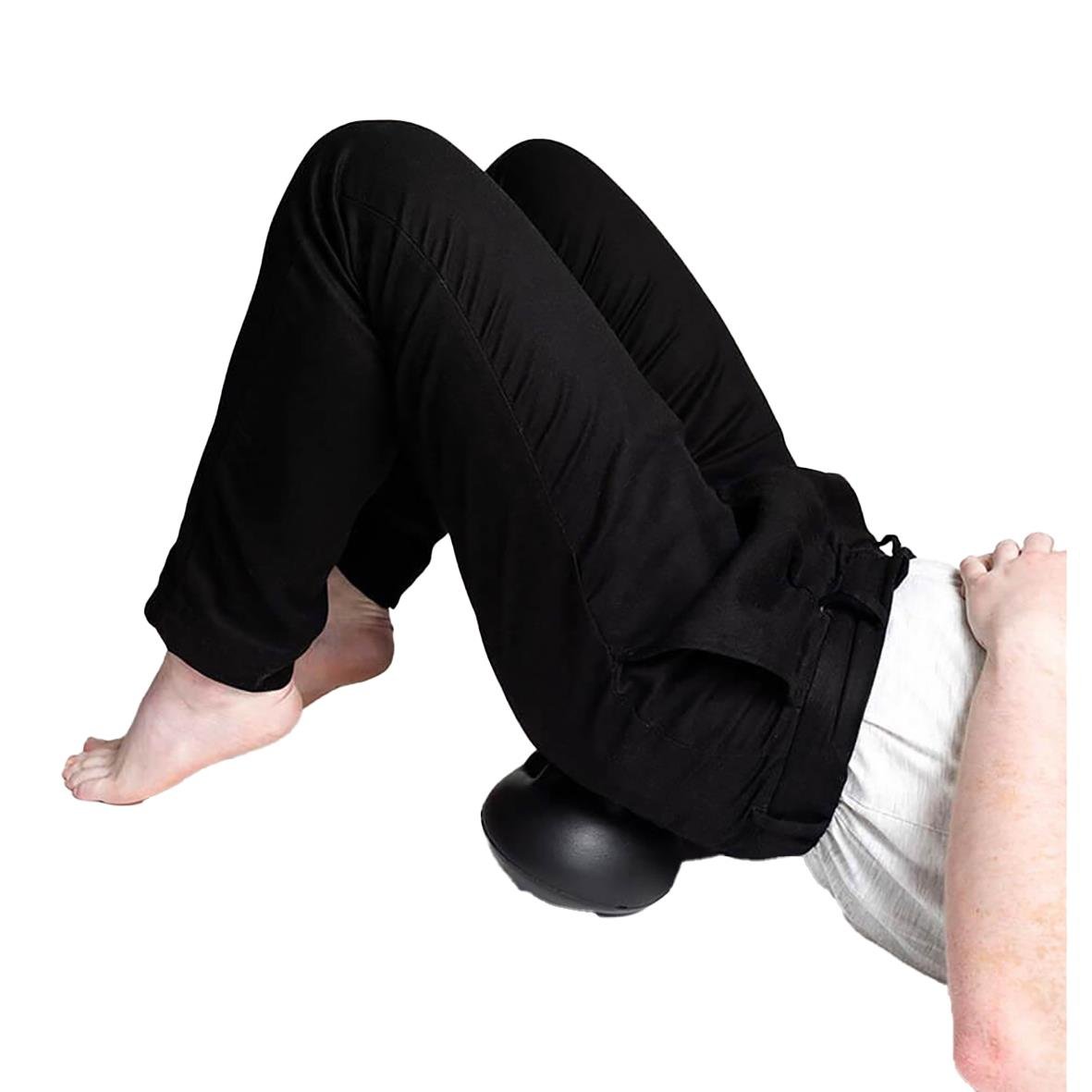 Person använder en massageboll för att behandla triggerpunkter i nacke och hållning