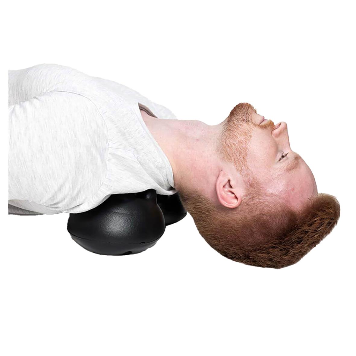 Man ligger på en massageboll för att lindra triggerpunkter i nacken och förbättra hållningen