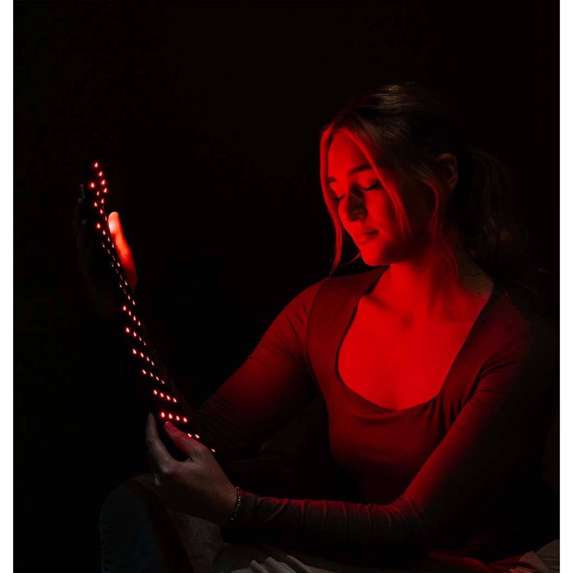 Kvinna använder Bälte InfraEaz med infrarött ljus i mörkt rum