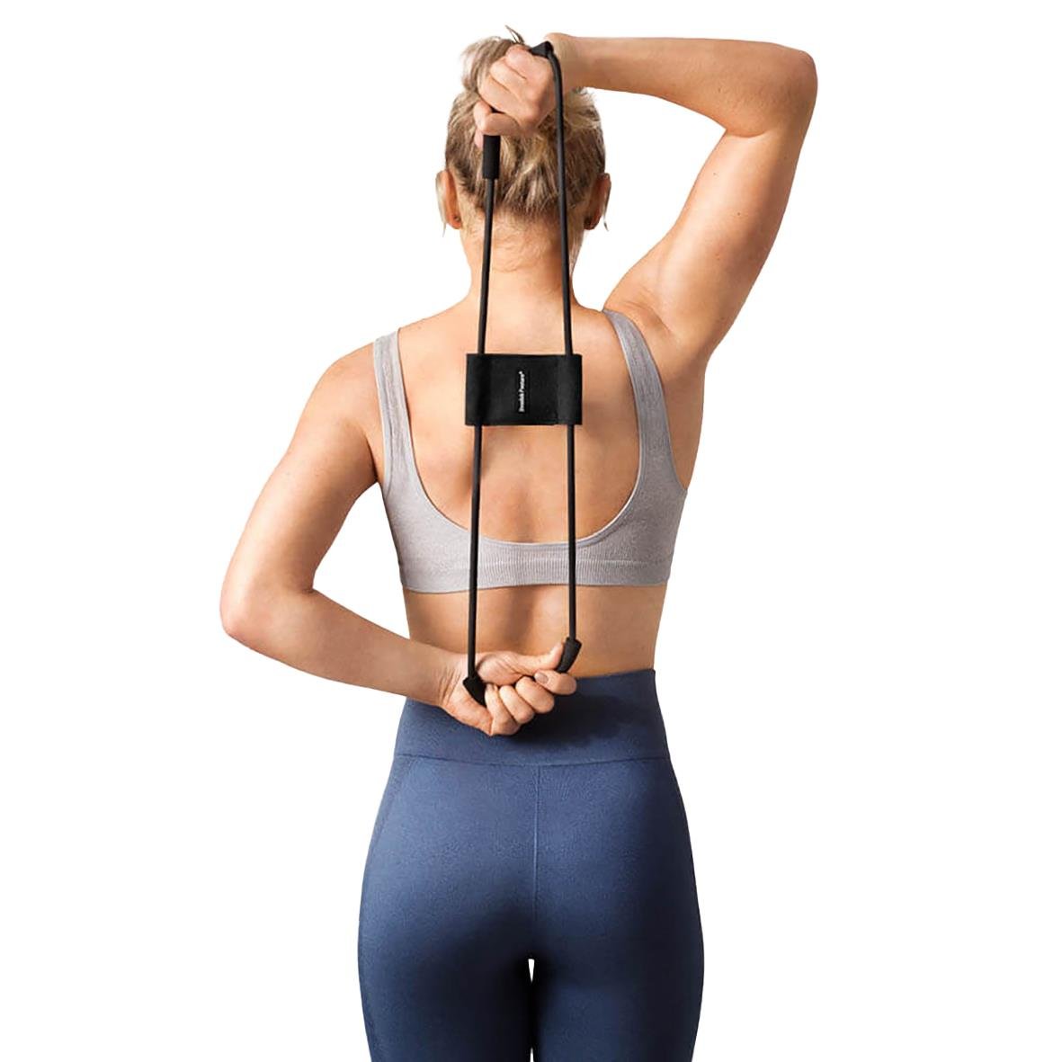 Kvinna använder träningsband för att förbättra hållning med Posture Trainer 3in 1