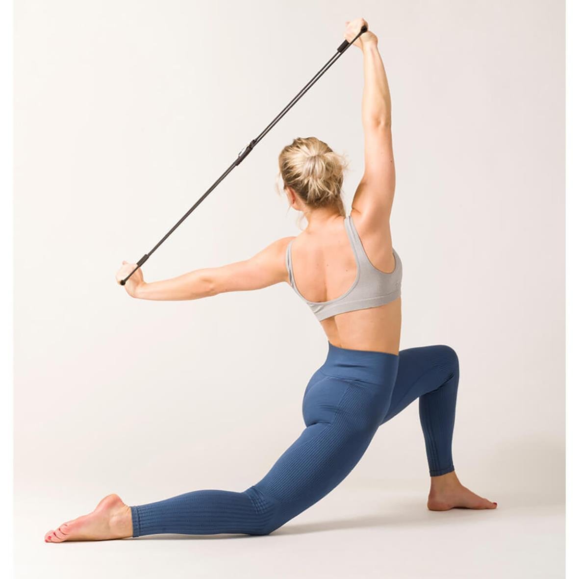 Kvinna tränar med träningsband för hållning och styrka i en stretchposition